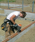 Worker using a nail gun with N10DHDGPT2500 Strong-Drive 33 SCN Smooth-Shank Connector Nail Two And One-Half Inch HDG on framing