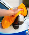 Hand uses Ultra Plush Dual-Sided Microfiber Car Towels For Washing And Detailing, Scratch-Free And Highly Absorbent on side mirror
