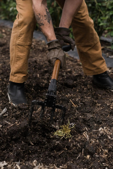 Gardener using foldable spading fork for digging and aerating durable steel garden tool with easy twist lock, in soil