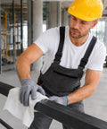 Worker cleaning a metal bar with Recycled White Cleaning Rags Bulk 5 Lb Box Lint Free Cotton Cloths for Auto Shop Manufacturing