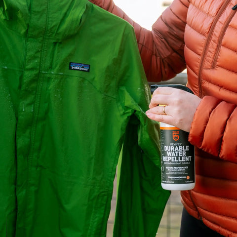 Person applying Revivex DWR Spray For Waterproof Jackets And Rain Gear Keeps Your Gear Dry And Gore-Tex Breathable With Water Beading Again