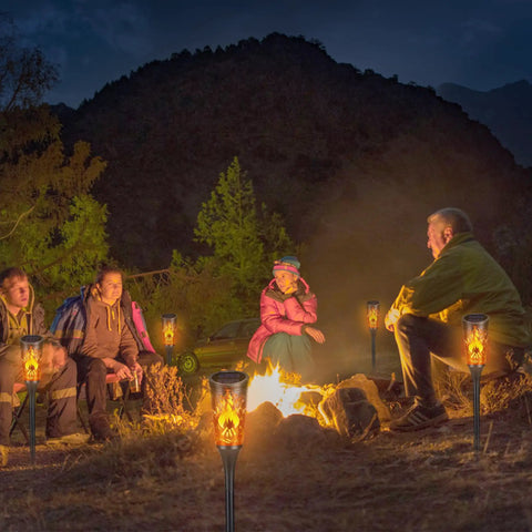 Super Cool Solar Torch Lights Outdoor Six Pack With Realistic Dancing Flickering Flames installed around campfire at night.