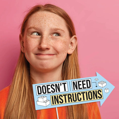 Girl smiling with sign saying 'Doesn't Need Instructions' at a birthday photo booth for Awesome Funny Building Blocks Birthday Photo Booth Prop Kit