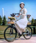 Woman riding Beast 1000W Peak Electric Bike for Adults with 22 MPH Top Speed, 60 Mile Range, holding flowers, small dog in basket