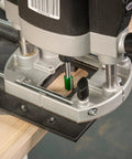 Close-up of Rock Solid Trim Base For Hardwood Lipping Quick Swap Router Adapter attached to a router for precise edge trimming.