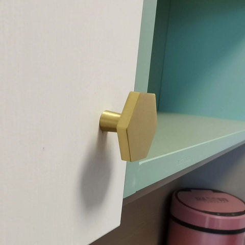 Top Tier Solid Brushed Brass Hexagon Knobs 6 Pack For Kitchen Cabinets And Drawers With Mounting Hardware 1.2 Inch Design on white cabinet.
