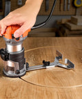 Heavy Duty Rock Solid 1 HP Wood Router 710W Variable Speed Palm Router With Soft Start Fixed Base cutting a circle in wood.