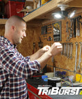 Man installing Triburst Motion Sensor LED Ceiling Light With 144 LEDs, 6500K Daylight in garage workshop.