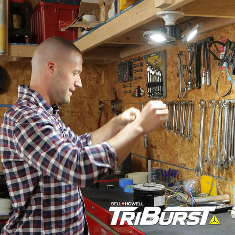 Man installing Triburst Motion Sensor LED Ceiling Light With 144 LEDs, 6500K Daylight in garage workshop.