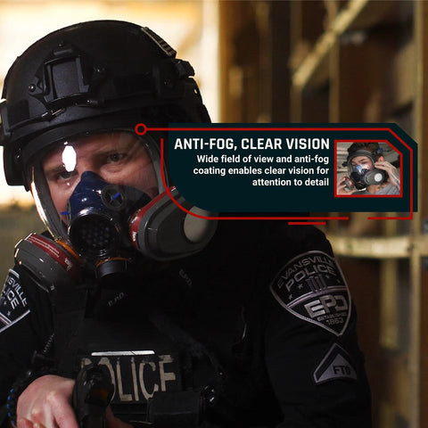 Person wearing industrial-grade full face respirator mask with anti-fog scratch-resistant lens in a tactical setting.