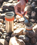 All In One Portable Coffee Maker With Vacuum Pressure Brew Hand Powered On The Go Coffee Brewer Insulated Stainless Steel Travel Mug 10 Ounce Thermo Cup Quick Fresh Brew For Commutes And Outdoors on rocks with hand pouring coffee