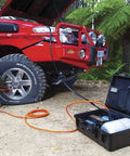 Heavy Duty Road Trip Ready 12 Volt Twin Motor Portable Air Compressor in use on off-road truck tire.