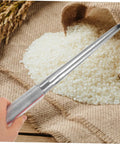 Stainless Steel Grain Sampler Probe Tool With Rubber Grip For Outdoor Gardening And Farm Use held over a sack of grains.