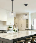 BOKUNOFU Glass Pendant Light Kitchen Island, Modern Black Pendant Light with Hammered Glass Shade over white kitchen island countertop.