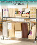 No Bull Heavy Duty Packing Station Cart With Fully Adjustable Height Steel Wire Shelving Plus Smooth Rolling Locking Casters organizing art supplies in a studio.
