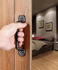 Hand opening a door with Four Pack Cast Iron Sliding Barn Door Handles 5.51 Inch Dark Brown Vintage Metal Pulls for interior use