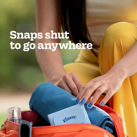 Person placing Snap And Go Ultra Soft Facial Tissues Travel Size Four On The Go Packs With Twenty Five Tissues Per Pack in bag.