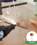 Close-up of a Dremel rotary tool with a brown abrasive buffing wheel grinding a metal piece, sparks flying.