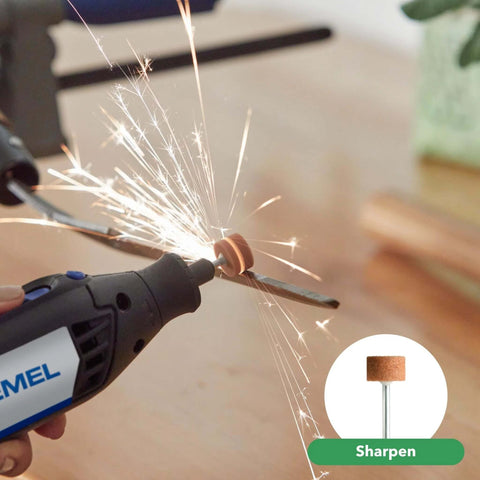 Close-up of a Dremel rotary tool with a brown abrasive buffing wheel grinding a metal piece, sparks flying.