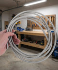 Heavy Duty Stainless Steel Bendable Conduit Sleeve for Weatherproof Cable Management, held in hand, flexible for garage projects.