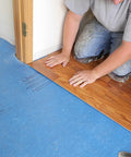 Top Tier Floating Floor Underlayment 200 Square Foot Roll With Hella Punchy Sound Dampening And Knockout Moisture Shield Sweetly Crafted For Laminate And Hardwood Floors Featuring 3Mm Density And Recycled Build Made Right Here In Usa being installed under laminate flooring.