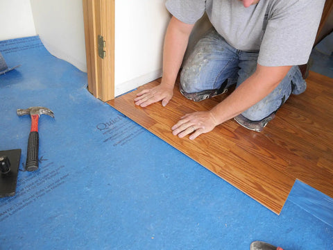 Top Tier Floating Floor Underlayment 200 Square Foot Roll With Hella Punchy Sound Dampening And Knockout Moisture Shield Sweetly Crafted For Laminate And Hardwood Floors Featuring 3Mm Density And Recycled Build Made Right Here In Usa being installed under laminate flooring.