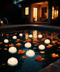 7 Piece Battery Operated Flameless LED Candles With Remote Timer, Waterproof Indoor Outdoor, floating in a pool at night