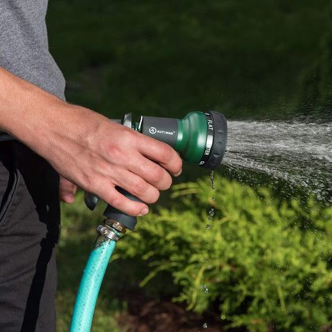 Person using Durable ABS Garden Hose Nozzle With Seven Adjustable Sprays For Easy Watering of Plants, showing flat spray pattern.