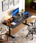 Home office setup with Electric Standing Desk 71 By 30 Inch Built To Be A Workhorse With Quiet Brushless Motor Height Adjustment Four Memory Presets Sit Stand Home Office Computer Desk With Thick T Shaped Frame, featuring dual monitors, keyboard, mouse, and decor, against an art-adorned wall.