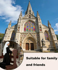 Nun using Foldable Wooden Prayer Kneeler With Padded Cushion in front of large cathedral with stained glass windows.