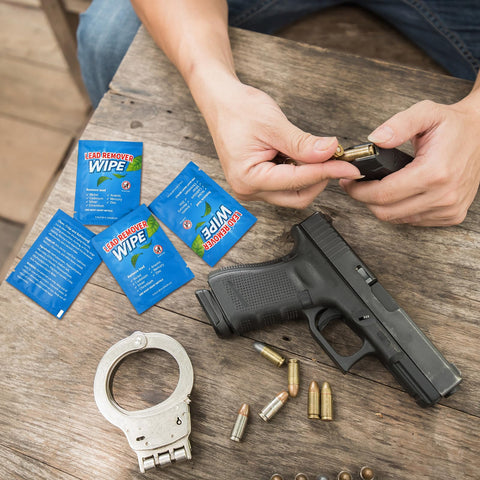 100 Pack Lead Remover Wipes for Shooting Ranges and Industrial Cleaning with firearm, bullets, and handcuffs on wooden table