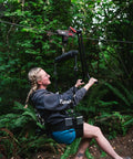 Person using All In One Zip Line Trolley Pro X With Brake Bundle Featuring Pro Grade Trolley Carabiner Heavy Duty Lanyard And Harness