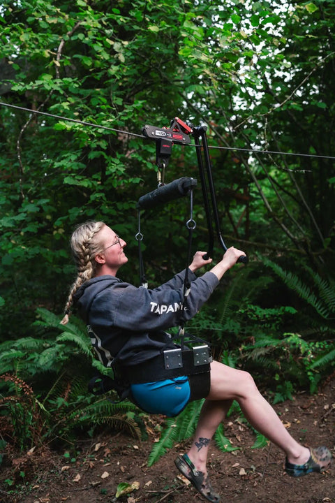 Person using All In One Zip Line Trolley Pro X With Brake Bundle Featuring Pro Grade Trolley Carabiner Heavy Duty Lanyard And Harness