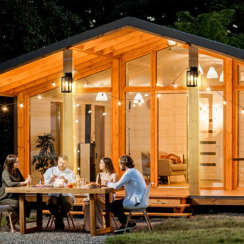 Outdoor gathering with Dusk To Dawn Motion Sensor Porch Light With Built In GFCI Outlet No Fuss Install Waterproof Anti Rust Exterior Wall Mount Outdoor Light With 3 Modes For Your Home Weatherproof Exterior Lighting Bulb Not Included illuminating a wooden patio.