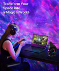 Galaxy Star Projector Night Light For Bedroom with pink and blue sky projection, timer, and Bluetooth speaker on desk.