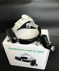 Headband loupe and light set on box with black strap and mounted light attachment