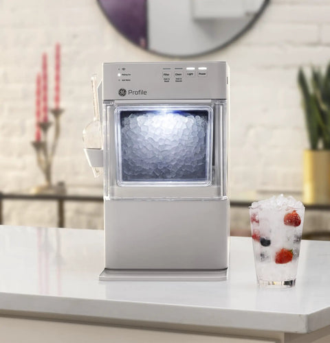 Legit Nugget Ice Maker, Portable Countertop Pellet Ice Machine in stone grey with pellet ice and drink on kitchen counter.