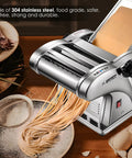 Newtry Electric Pasta Maker Machine With 3 Interchangeable Blades For Homemade Noodles processing fresh spaghetti on a wooden counter.