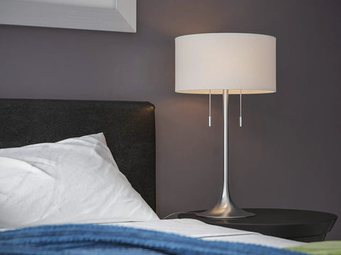 Stowe Table Lamp in Brushed Steel Finish With White Textured Drum Shade, Modern Vibe, bedroom nightstand setting, dual pull chains visible