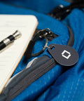 Key Fobs Four Pack NFC Enabled for Level Lock Plus Smart Locks Grey, Phone Free Access clipped on a blue backpack
