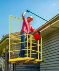 A man using Built Like A Tank 45 By 43 Forklift Safety Cage 1400 Lb Weight Capacity for roofing tasks with a gutter.
