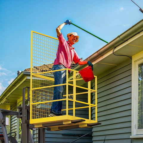 A man using Built Like A Tank 45 By 43 Forklift Safety Cage 1400 Lb Weight Capacity for roofing tasks with a gutter.