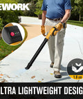 Man using Cordless Leaf Blower 21V Lightweight Electric Blower With 130 CFM And 200 MPH Wind Includes Dual 2.0Ah Batteries And Fast Charger Compact Mini Design For Lawn Care Leaves And Job Sites on a sidewalk