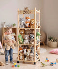 56 Inch Tall Wooden Stuffed Animal Storage Tower With Wheels in playroom, holding plush toys with child nearby