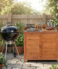 Outdoor Garden Wood Storage Cabinet With Waterproof Tool Shed, Potting Benches And Workstation Table In Natural Finish set next to a barbecue grill.