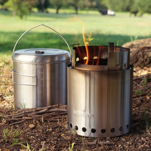 Pot 4000 Stainless Steel Camping Pot For Outdoor Cooking Lightweight Backpacking Cookware beside a lit campfire stove.
