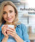 Woman with blonde hair in a denim shirt holding a white coffee cup in a kitchen; overlay text refreshing taste