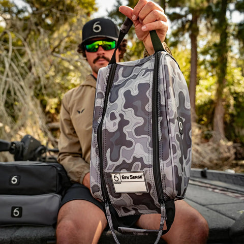 Man holding Beast Of A Tackle Bag For Fishing Gear And Soft Plastics, Extra Large, water-resistant, with dual zippers and grab handles.