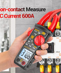 Hand holding All-In-One Digital Clamp Meter Multimeter For AC And DC Current And Voltage NCV Capacitance Resistance Diodes Continuity Frequency Backlit LCD 4000 Counts Handy Pro-Grade Electrician Tool For Quick Troubleshooting against electrical circuit