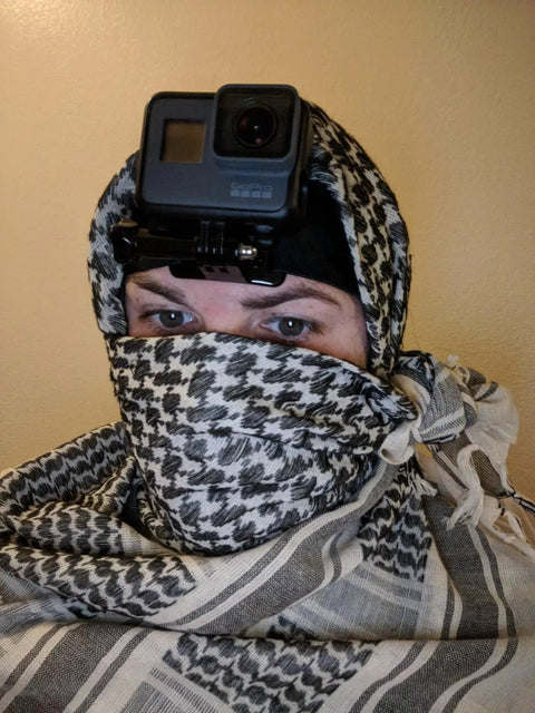 Person wearing Cotton Shemagh Keffiyeh Tactical Desert Scarf Neck Head Wrap With Tassel For Men And Women 41 By 43 Inches Tan